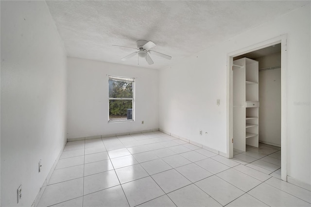 unfurnished bedroom with ceiling fan, a textured ceiling, and light tile patterned floors