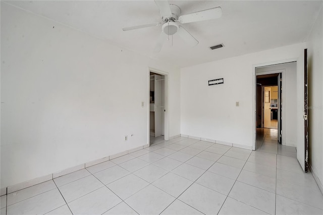 tiled spare room featuring ceiling fan