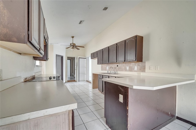 kitchen featuring kitchen peninsula, sink, light tile patterned floors, ceiling fan, and dark brown cabinetry