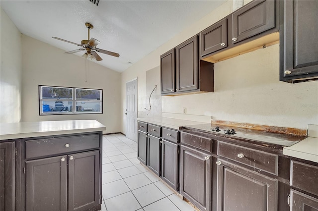 kitchen with lofted ceiling, light tile patterned floors, ceiling fan, dark brown cabinets, and black electric stovetop