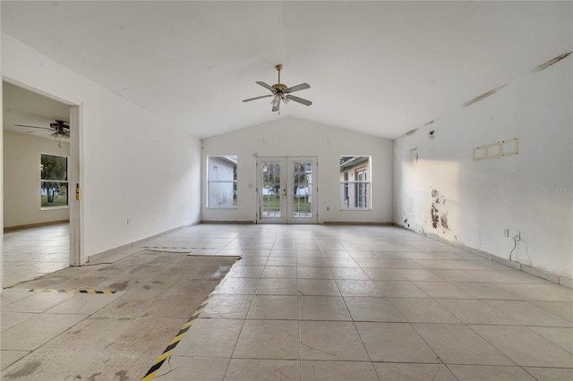 tiled spare room featuring vaulted ceiling, ceiling fan, and french doors