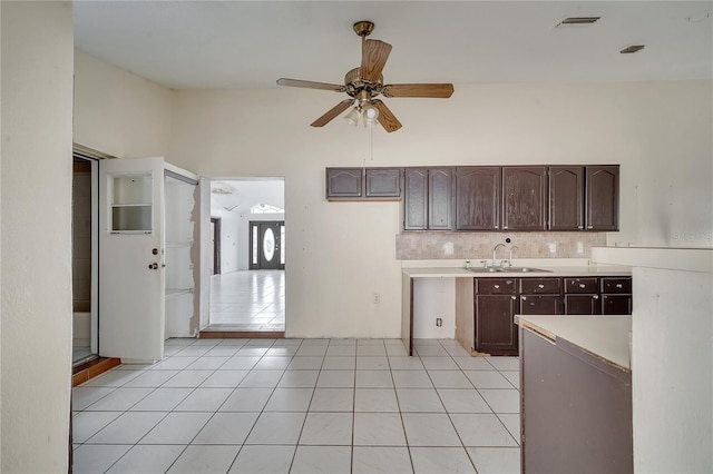 kitchen with sink, decorative backsplash, light tile patterned floors, ceiling fan, and dark brown cabinets