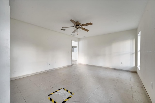 tiled empty room featuring ceiling fan