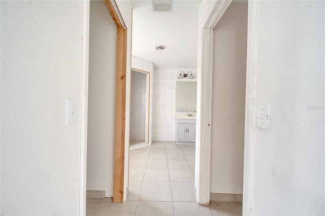 hallway featuring light tile patterned flooring and sink