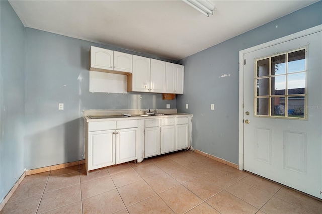 kitchen with white cabinetry, sink, and light tile patterned flooring