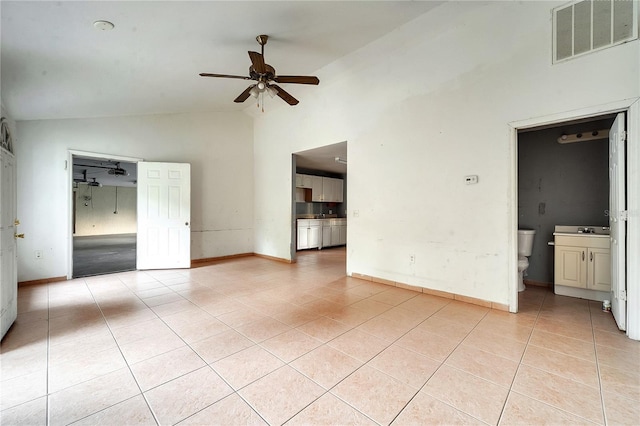 tiled empty room with ceiling fan, sink, and high vaulted ceiling