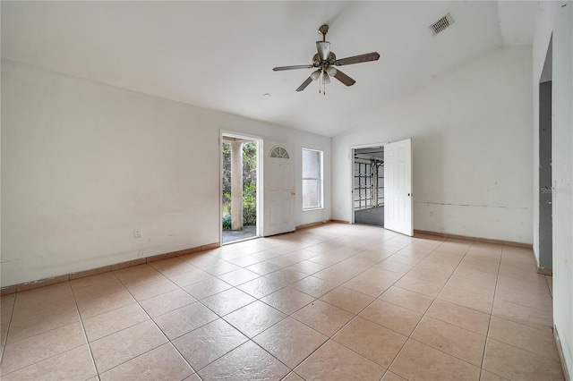 empty room featuring ceiling fan, lofted ceiling, and light tile patterned floors