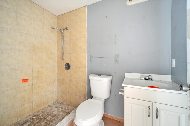 bathroom featuring vanity, toilet, and a tile shower