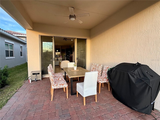 view of patio featuring ceiling fan, grilling area, and heating unit