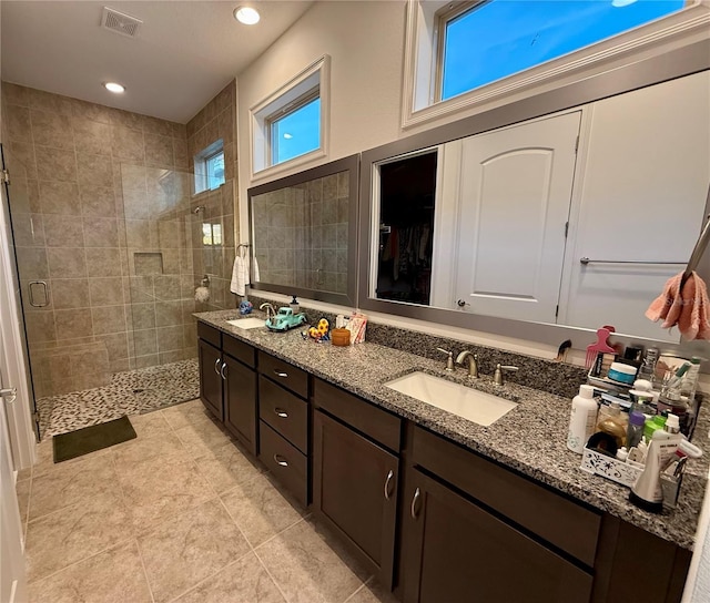 bathroom with vanity and a shower with door