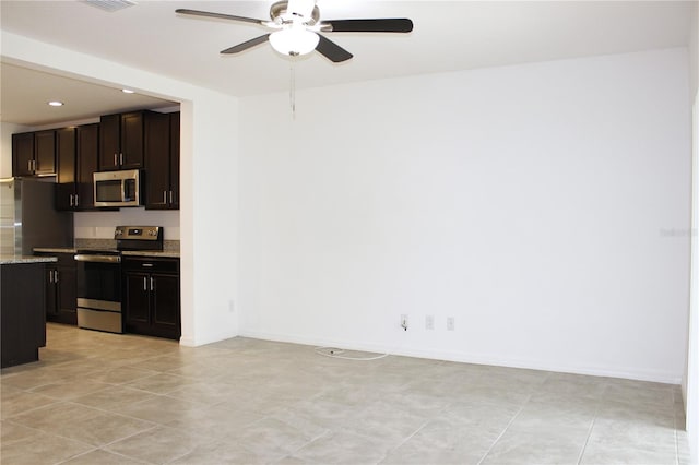 kitchen with stainless steel appliances, dark brown cabinets, light stone counters, and ceiling fan