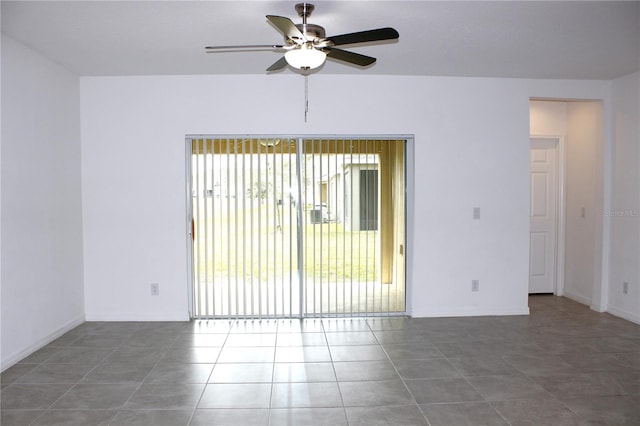 unfurnished room featuring dark tile patterned floors and ceiling fan