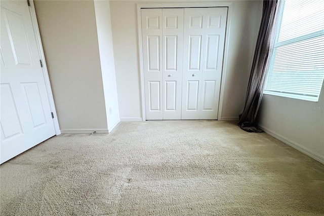 unfurnished bedroom featuring carpet flooring and a closet