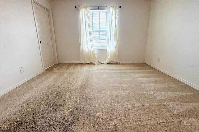 unfurnished room featuring light carpet