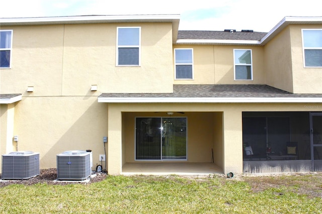 back of property featuring central AC unit, a yard, and a patio