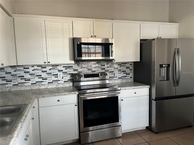 kitchen with tasteful backsplash, white cabinetry, appliances with stainless steel finishes, and sink