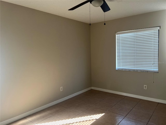 spare room with tile patterned flooring and ceiling fan