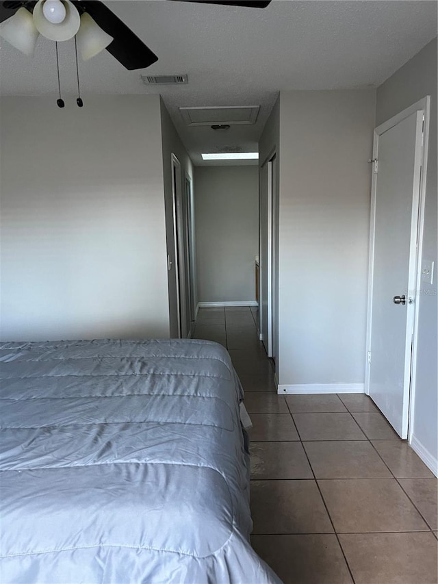 unfurnished bedroom with ceiling fan and dark tile patterned floors