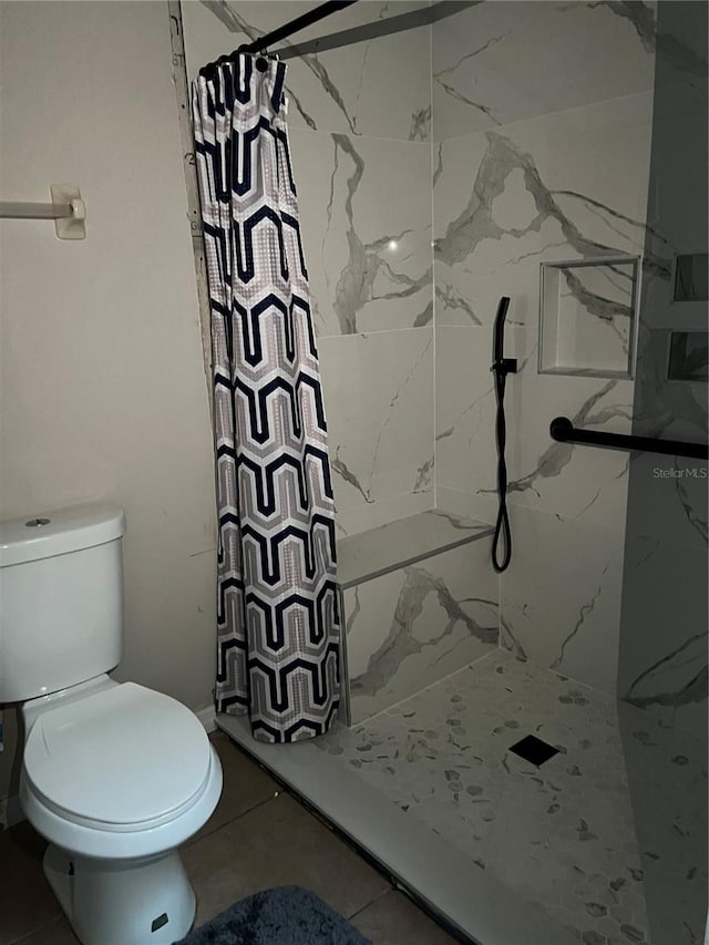 bathroom featuring tile patterned flooring, curtained shower, and toilet