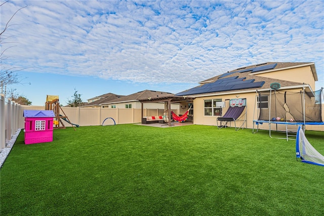 view of yard featuring a trampoline, a patio, and a playground