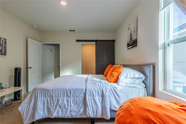 bedroom featuring carpet flooring and a barn door