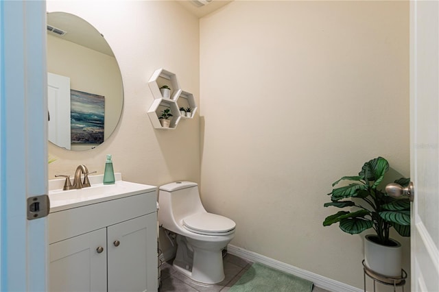 bathroom featuring tile patterned floors, vanity, and toilet