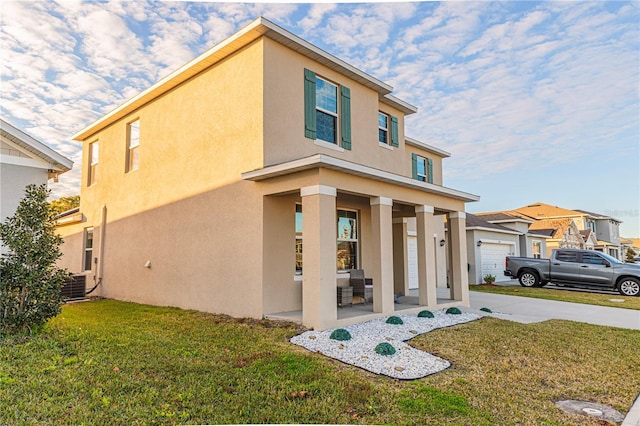 view of front of house with central air condition unit and a front lawn