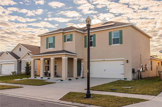 view of front of property with a garage, a yard, and solar panels