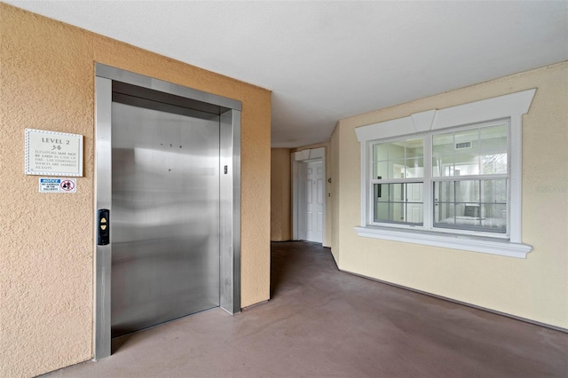 hallway featuring carpet flooring and elevator