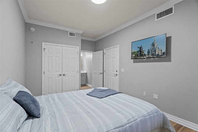 bedroom featuring connected bathroom, hardwood / wood-style floors, and crown molding