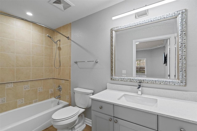 full bathroom with vanity, tiled shower / bath combo, and toilet