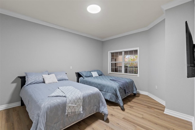 bedroom with ornamental molding and light wood-type flooring