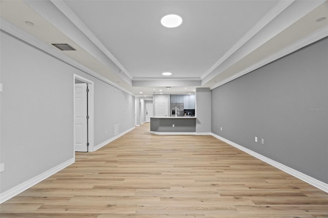 unfurnished living room with crown molding and light wood-type flooring