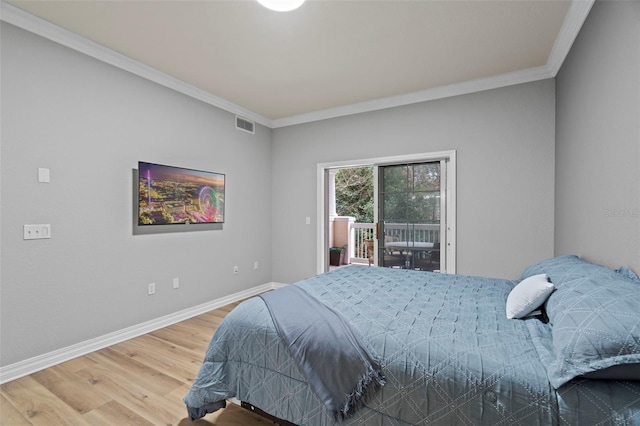 bedroom with ornamental molding, wood-type flooring, and access to exterior