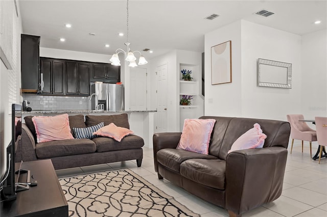 living area with recessed lighting, visible vents, a notable chandelier, and light tile patterned flooring