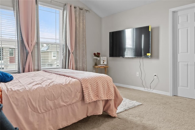 carpeted bedroom with vaulted ceiling and baseboards