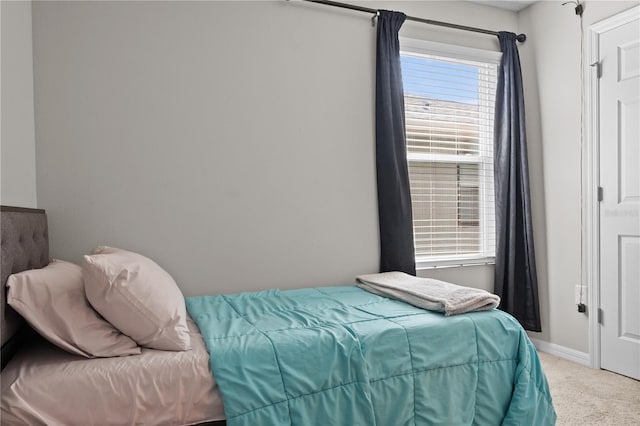 bedroom with light carpet and baseboards