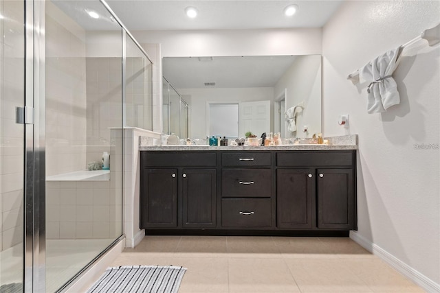 bathroom featuring tile patterned floors, a shower with door, and vanity