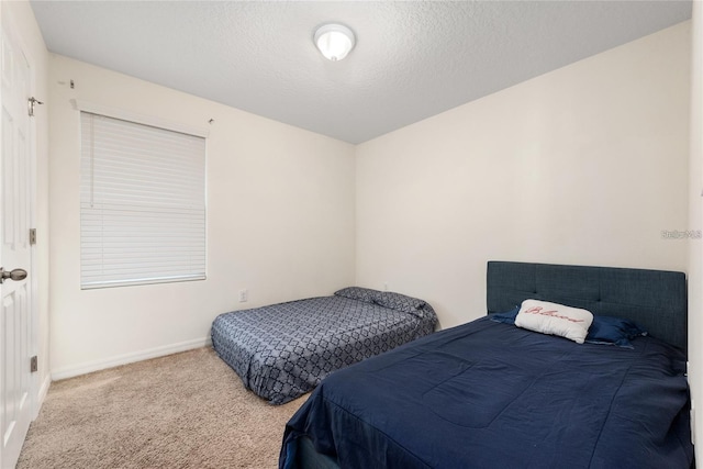 bedroom with light carpet and a textured ceiling