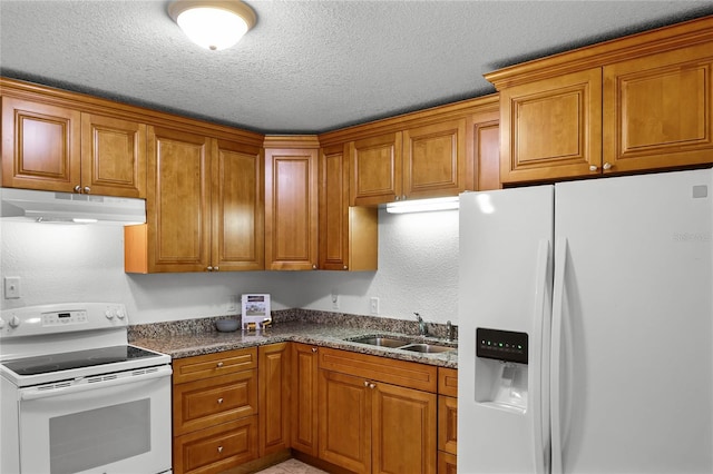 kitchen with sink, a textured ceiling, white appliances, and dark stone counters