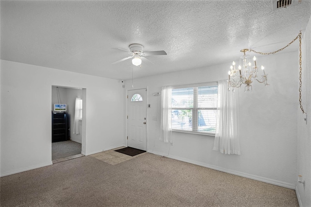 foyer with ceiling fan with notable chandelier, light carpet, and a textured ceiling