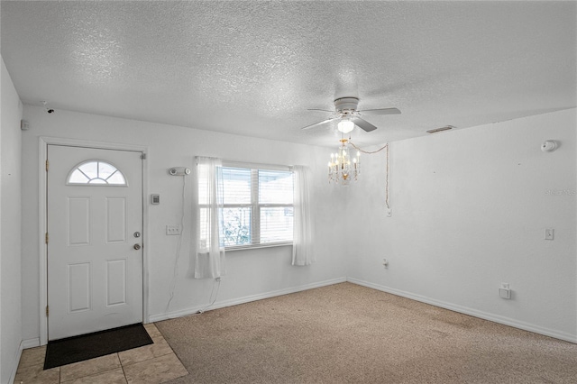 carpeted entryway with ceiling fan with notable chandelier and a textured ceiling