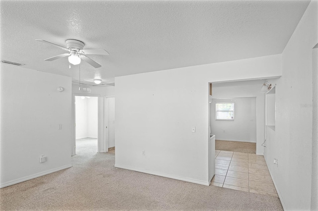 carpeted empty room with a textured ceiling and ceiling fan