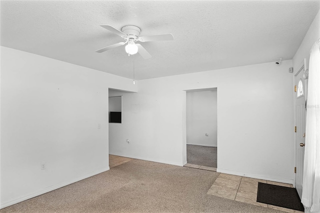 carpeted empty room with ceiling fan and a textured ceiling