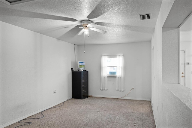 carpeted empty room with ceiling fan and a textured ceiling