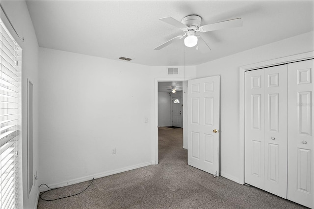 unfurnished bedroom featuring multiple windows, carpet floors, a closet, and ceiling fan