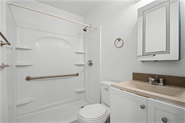 bathroom with toilet, vanity, and walk in shower