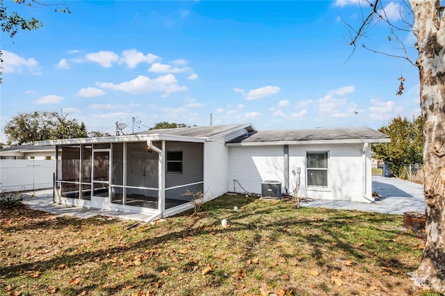 rear view of property featuring cooling unit, a patio area, a sunroom, and a lawn