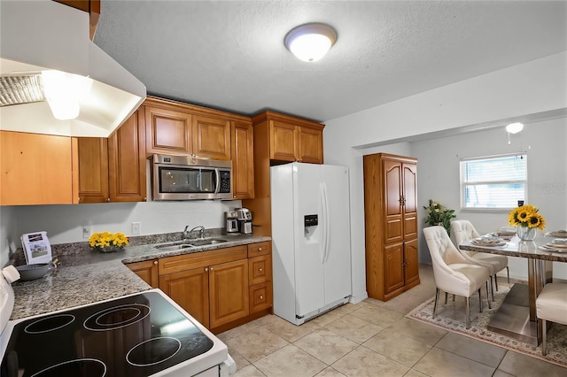 kitchen with sink, light tile patterned floors, a textured ceiling, and white appliances