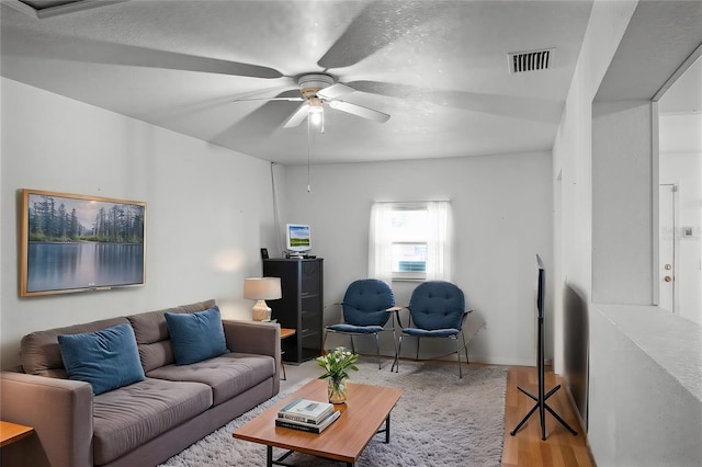 living room with wood-type flooring and ceiling fan